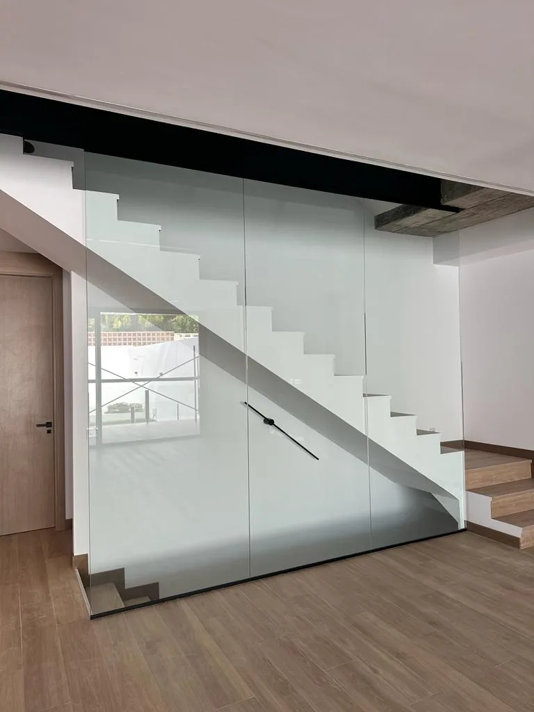 Escalera flotante de madera con cerramiento de vidrio templado